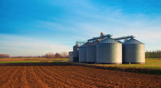 photo of silos behind tilled land